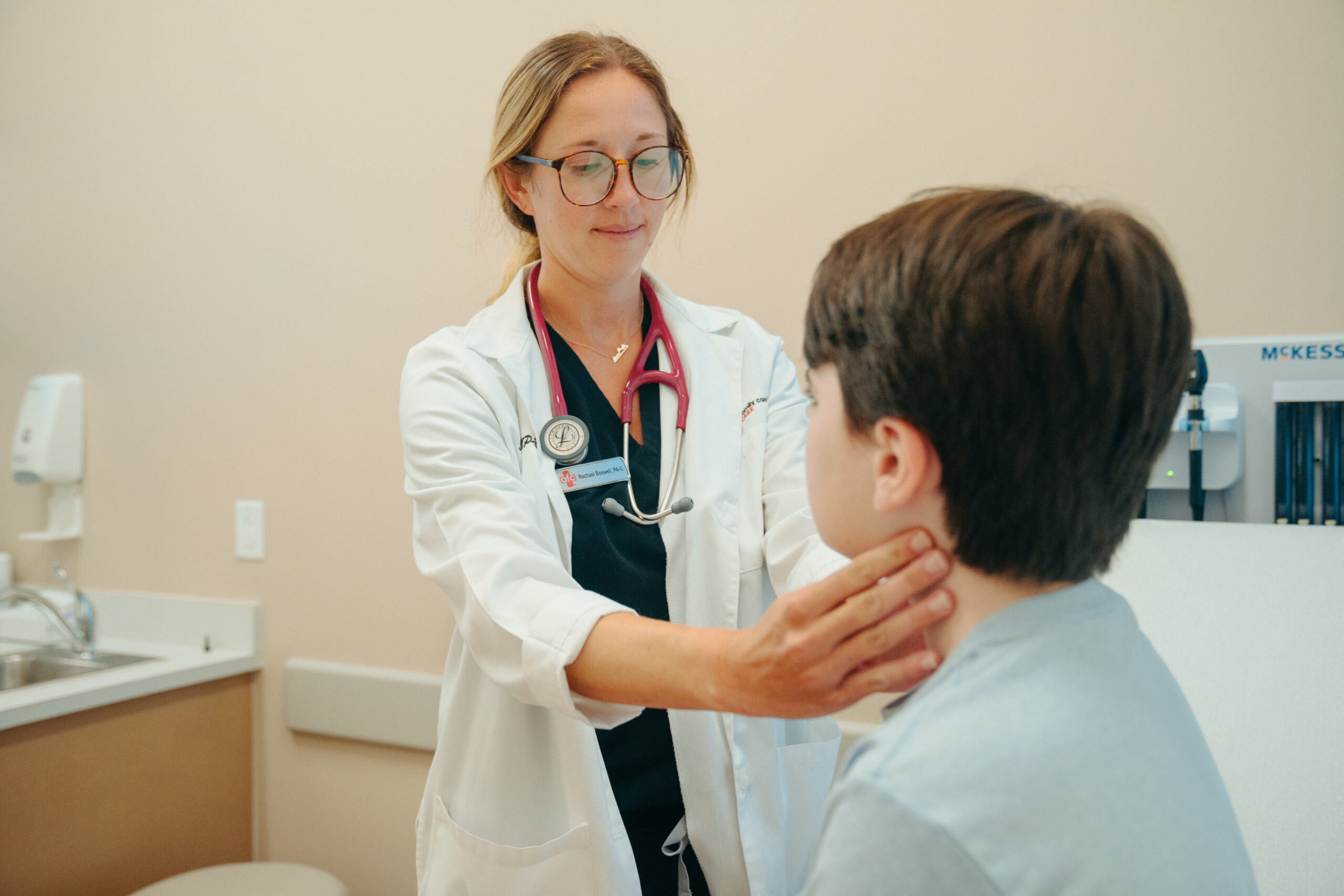 AFC provider checks young patient's lymph nodes, examining for RSV