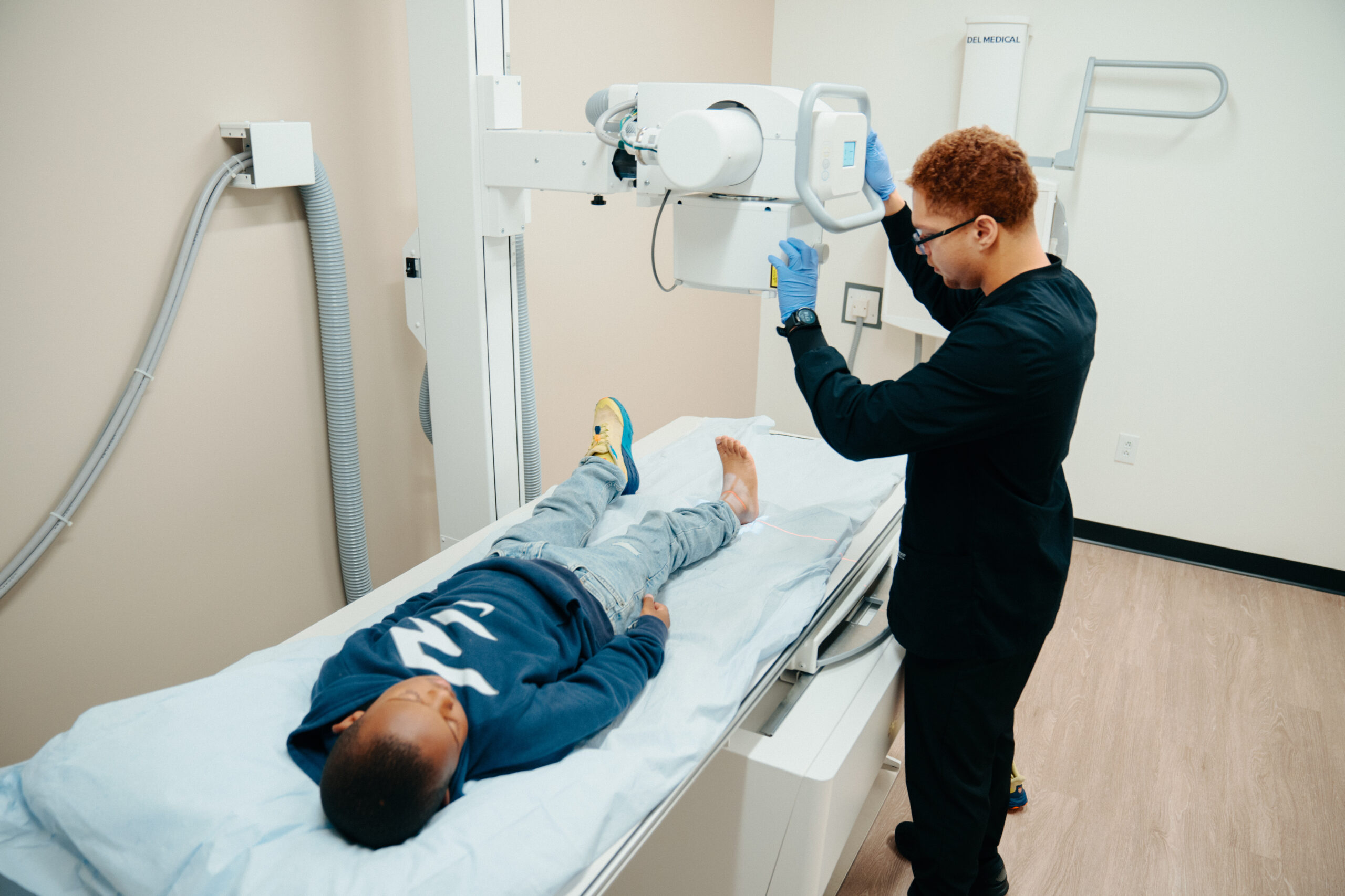 X-Rays Medical technician preparing a young male patient for a digital X-ray scan in an urgent care exam room